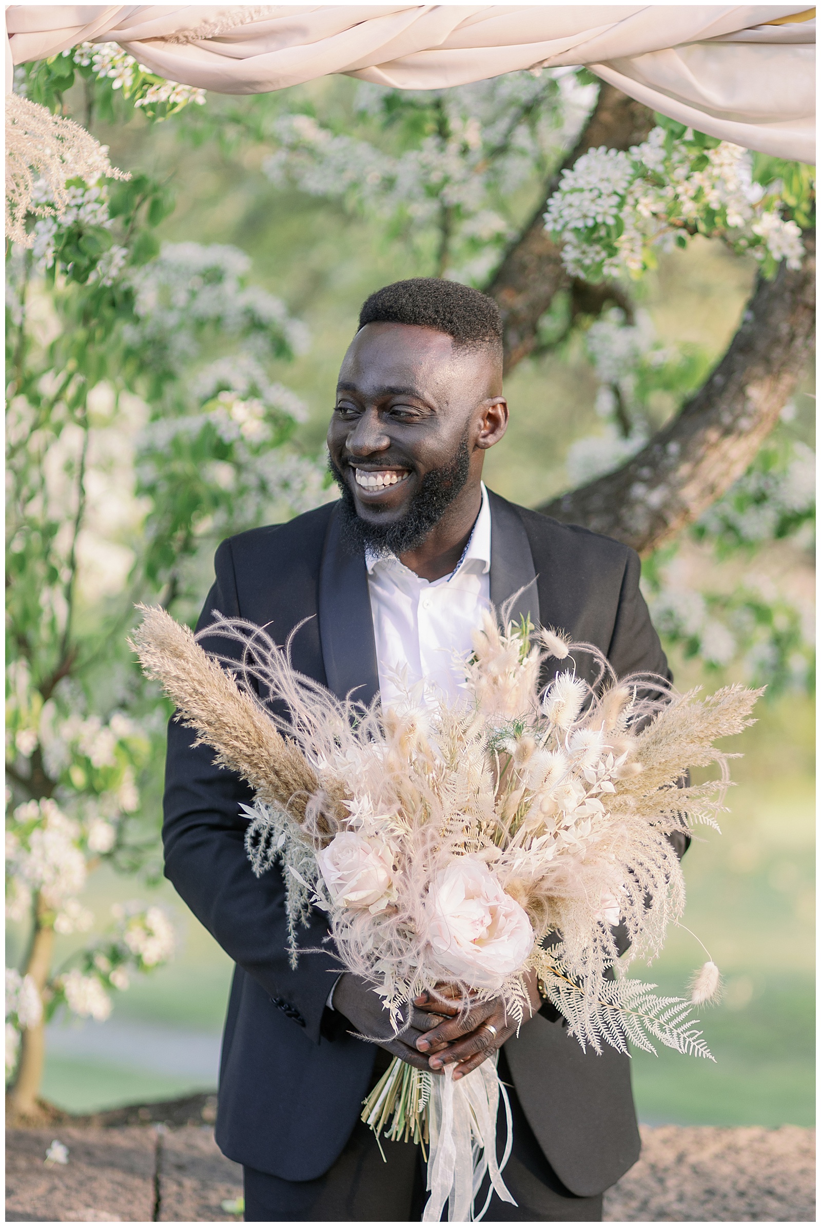 Groom holding bridal bouquet