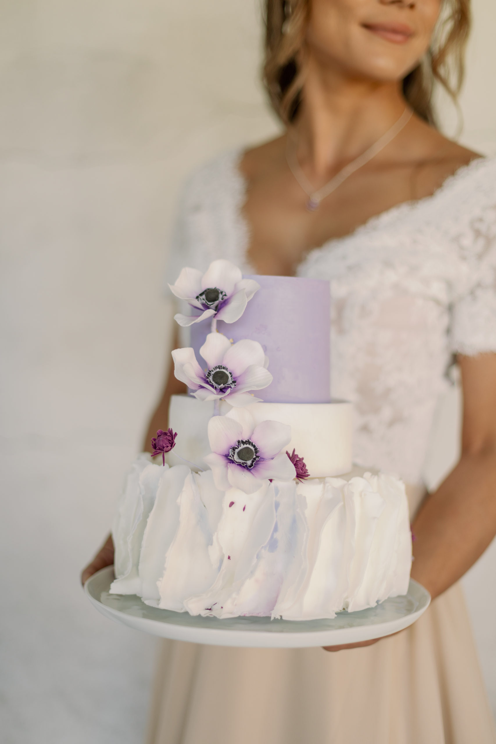Bröllopstårta i vit och lila med sockerblommor