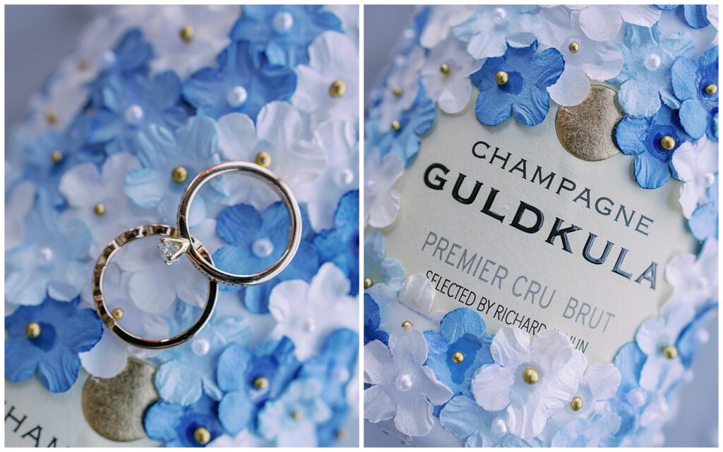 Detaljbild av vigselringar och champagne på blåvita blomblad, stylat inför bröllop i Tällberg, Dalarna | Detail photo of wedding rings and champagne on blue and white petals, styled for a wedding in Tällberg, Dalarna