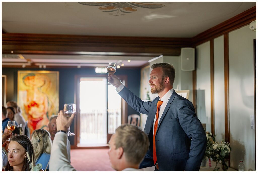 Gäster lyssnar och skrattar under talen vid bröllopsmiddagen på Green Hotel i Tällberg. / Guests listening and laughing during speeches at the wedding dinner at Green Hotel in Tällberg.