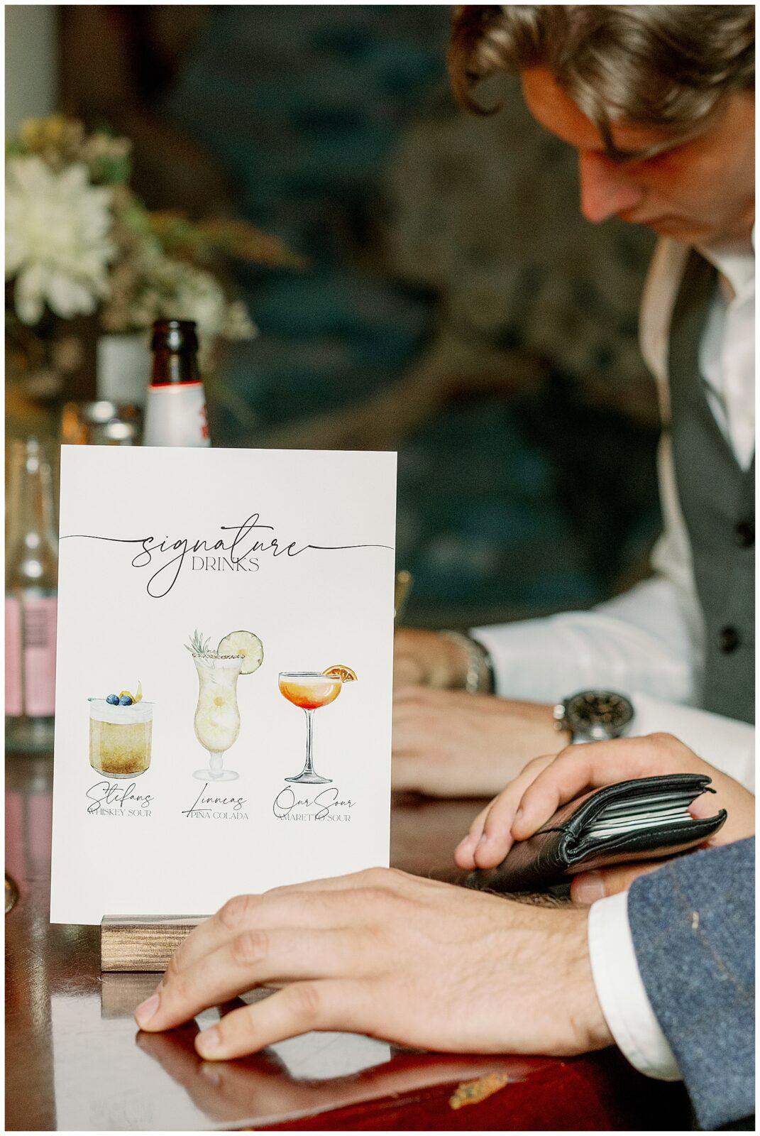 Detaljbild på skylt med brudparets signaturdrinkar placerad på bardisken under bröllopsfesten på Green Hotel i Tällberg. Dokumentär bröllopsfotografi i Dalarna av bröllopsfotograf Dalarna. Close-up of a signature drinks sign displayed on the bar during the wedding party at Green Hotel in Tällberg. Documentary wedding photography in Dalarna by a wedding photographer in Dalarna.